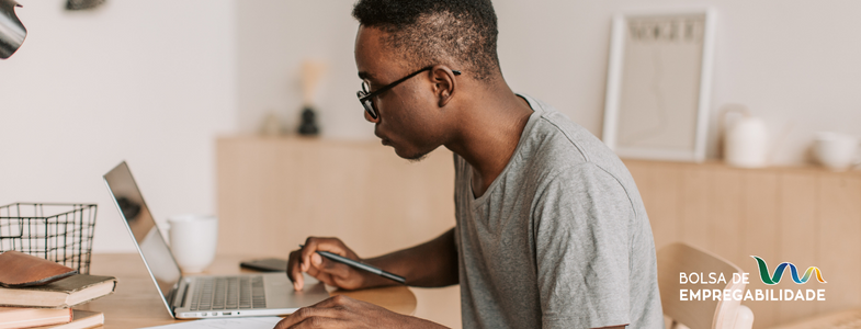 Imagem de um rapaz a escrever uma carta de motivação no computador. Representa a importância e facilidade de criar uma carta de motivação, e como isso pode influenciar as hipóteses de contratação.